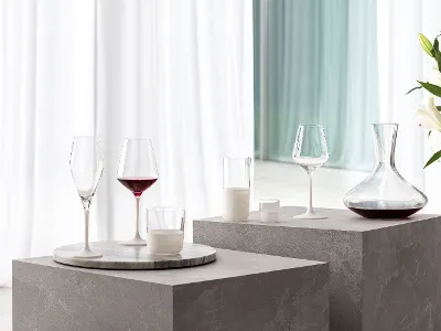 Une carafe à vin Maxima avec des verres Manufacture Des verres Manufacture sur une table à côté d’une élégante carafe à vin Maxima.