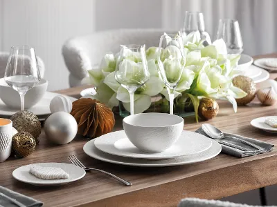 Gedeckter Esstisch mit Manufacture Rock Blanc von Villeroy & Boch Ein hübsch gedeckter Esstisch mit der Manufacture Rock Blanc-Kollektion von Villeroy & Boch in Weiß, ergänzt durch Glaswaren, Silberbesteck und einem Tafelaufsatz aus weißen Blumen und dekorativen Ornamenten.