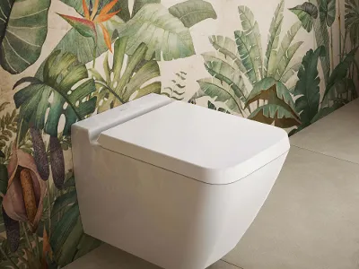 WC Finion bianco con sedile davanti a carta da parati con motivo di piante Un WC Finion sospeso con sedile e coperchio è fissato a una controparete con un motivo di piante.