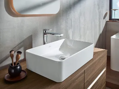 Lavabo e mobili sottolavabo Collaro in un bagno moderno con vista mare Interno bagno moderno con lavabo e mobiletti in legno della collezione Collaro sullo sfondo di una finestra con vista sul mare.