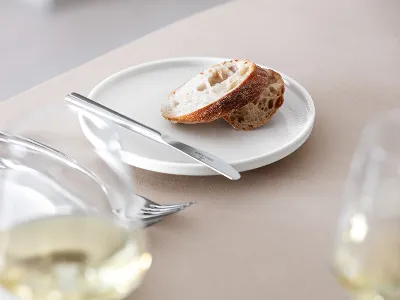 White Afina bread plate with bread and a knife Villeroy & Boch Afina bread plate with bread and an Afina knife.
