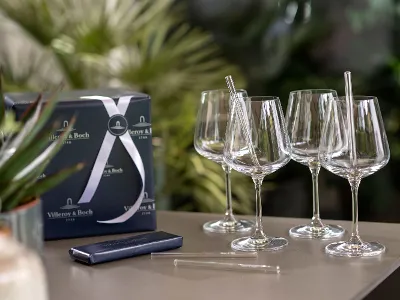 A group of Ovid wine glasses on a table. A group of Ovid wine glasses with Purismo glass straws on a table.