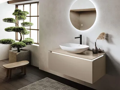 Lavabo Loop&Friends bianco con mobile sottolavabo Legato Bagno moderno con lavabo da appoggio Loop & Friends bianco su mobile sottolavabo Legato beige, specchio rotondo, grandi finestre e un bonsai su sgabello in legno