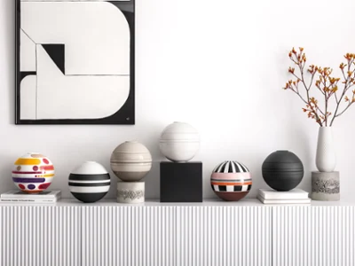 Une étagère blanche avec plusieurs ensembles de vaisselle La Boule posés dessus.