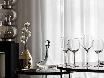 Vinobile wine decanter with Allegorie wine glasses A group of Allegorie wine glasses and an elegant Vinobile wine decanter with flowers on a table.