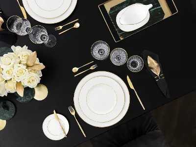 Elegant white porcelain with gold accents Table setting with white porcelain, golden accents, modern flatware, and white-yellow roses.