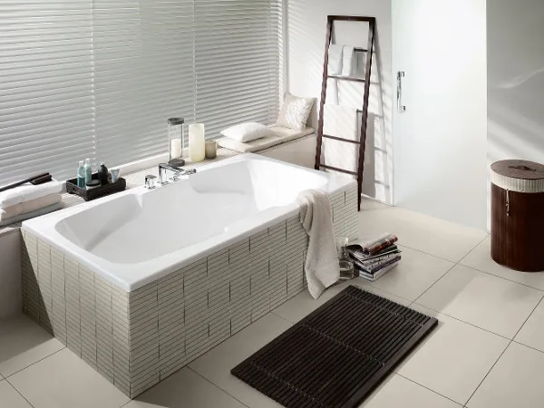 Colorado Badewanne weiss im beigen Badezimmer Eine weiße Colorado Badewanne in einem beigen Bad von Villeroy & Boch mit dekorierter Fensterbank.
