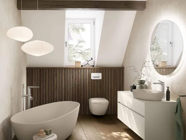 Badezimmer im Japandi Stil mit Dachschrägenbad Japandi Badezimmer mit freistehender 'Antao'-Badewanne, wandmontierter 'Antao'-Toilette und Aufsatzwaschbecken auf einem weißen 'Collaro'-Waschbeckenunterschrank.