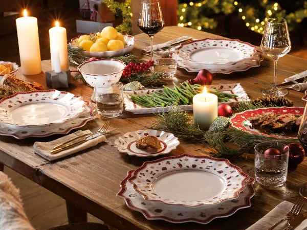 Una mesa de fiesta con platos, vasos y cubiertos Toy's Delight de Villeroy & Boch. Una mesa de fiesta con platos, vasos y cubiertos con decoración Toy's Delight de Villeroy & Boch, velas encendidas y adornos navideños completan el ambiente.