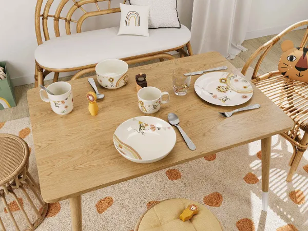 Kindergeschirr Boho Kids Roar like a lion auf Holztisch im gemütlichem Esszimmer Ein gemütliches Esszimmer mit einem Holztisch, Korbstühlen und buntem Kindergeschirr Boho Kids Roar like a lion.