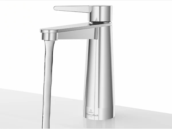 A modern chrome faucet with water flowing from it, mounted on a white washbasin against a plain background.
