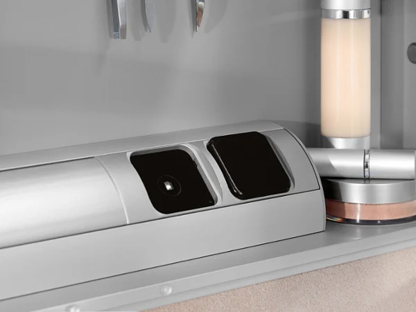 Close-up of a modern mirror cabinet with two sockets. Other bathroom accessories are also visible.