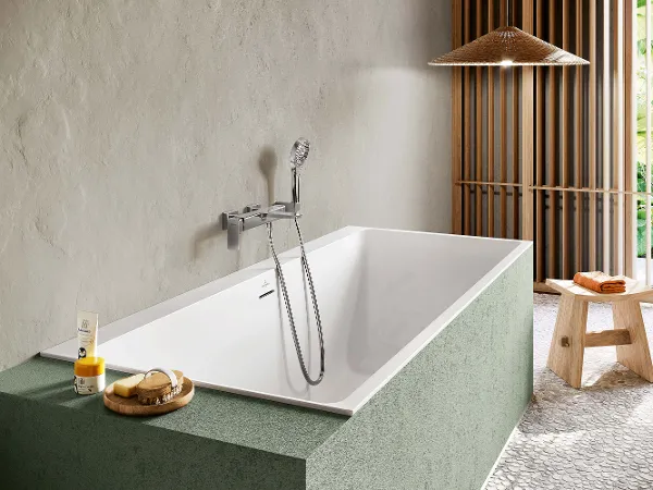 Weiße Subway 3.0 Badewanne in grüner Box Eine Subway 3.0 Badewanne in einem Badezimmer mit einer grünen Abmauerung.