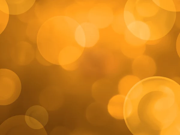 An abstract background featuring large and small golden-yellow bokeh circles against a blurred, warm-toned background.