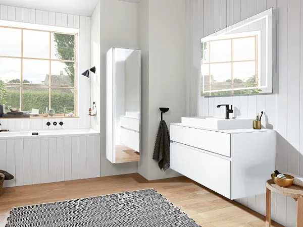 Specchio Finion in un bagno moderno e bianco Interno del bagno moderno con armadietti bianchi, grande specchio Finion, doppie finestre e pavimento in legno.