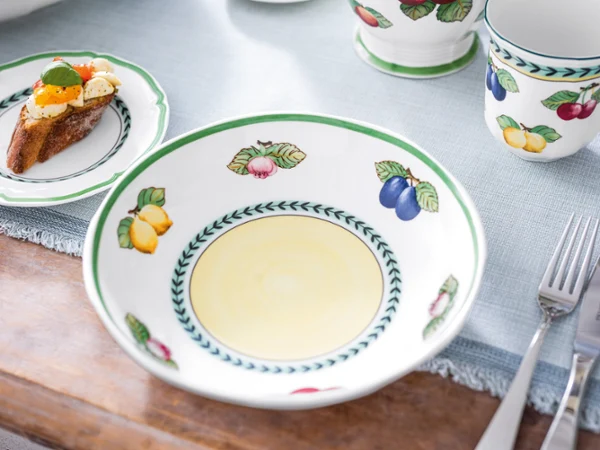 Empy french garden bowl on brunch table A brunch table setting with french garden tableware, an empty bowl, and a piece of toast.