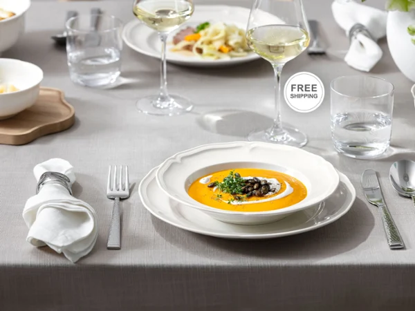 A closeup of a full Manoir table setting with free shipping callout sticker.