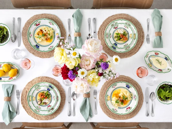 A table set with French Garden plates A table set for four with French Garden plates, linen napkins, salads, flowers in the centre and bowls of lemons and greenery