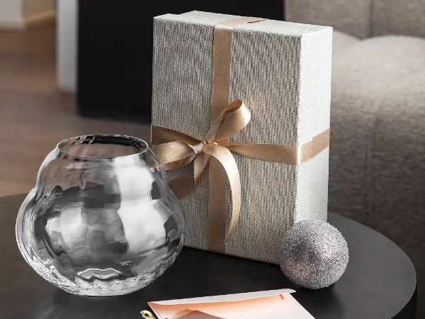 Dekorative Rose Garden Glasvase geschmückt auf einem Tisch Ein Tisch mit einer verpackten Geschenkbox, geschmückt mit einer hellen Schleife und einer dekorativen Rose Garden Home Glasvase