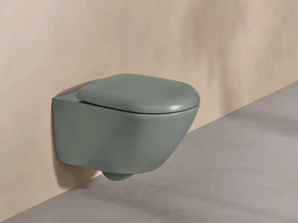 Antao green toilet with white push plate A Villeroy & Boch toilet from the Antao collection in green with a white control panel on a natural-coloured wall.