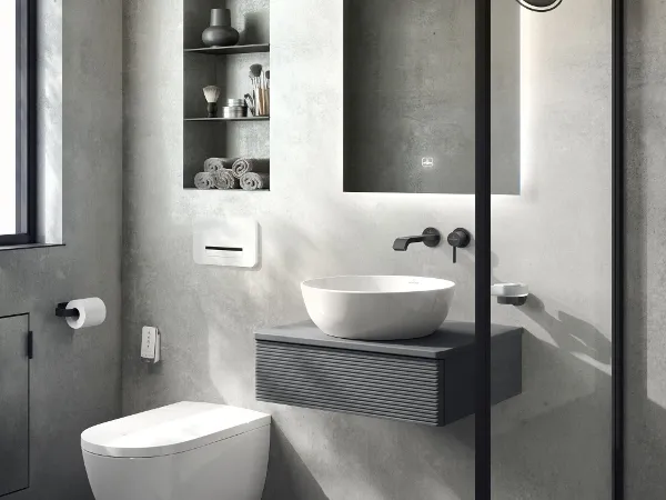 Bathroom with the Villeroy & Boch Artis, Antao collections and a ViClean shower toilet Modern bathroom with grey walls, a floating washstand, a white washbasin, a wall-mounted tap and a backlit mirror. Toilet and open shelves with towels and toiletries. A glass shower cabinet is visible on the right.