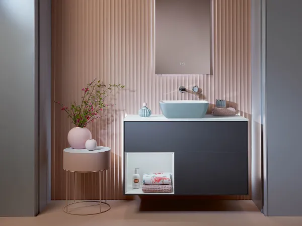 Finion Waschbeckenunterschrank Finion Waschbeckenunterschrank dunkelblau von Villeroy & Boch im rosa Bad mit rosa Couchtisch.
