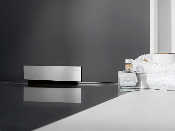Un système de douche Wallway blanc Le système de douche Wallway de Villeroy & Boch et une serviette de toilette blanche.