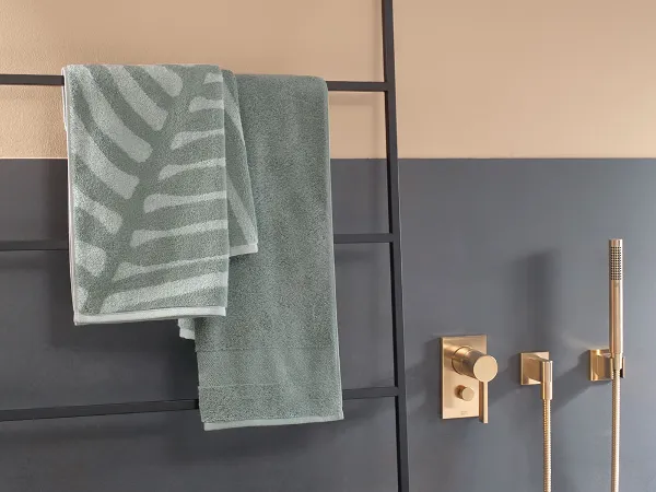 Grüne One Handtücher im Badezimmer auf einem Handtuchhalter Ein Badezimmer mit grünen Handtüchern aus der Kollektion One von Villeroy & Boch.