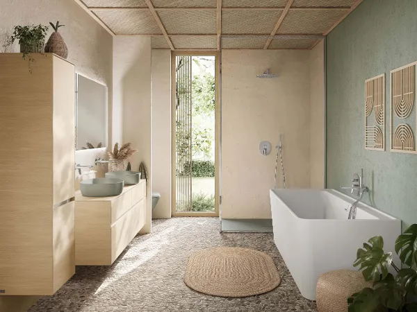WC im Boho-Badezimmer Wandhängendes Villeroy & Boch Antao WC in Grün vor einer strukturierten beigen Wand und Steinboden. An der Seite hängen Handtücher.