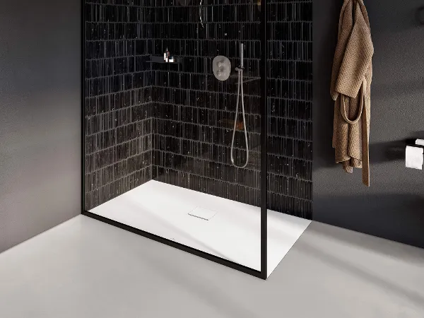 Plato de ducha Squaro Infinity en un cuarto baño blanco y negro Un cuarto de baño en blanco y negro con una cabina de ducha de cristal y un plato de ducha Squaro Infinity.