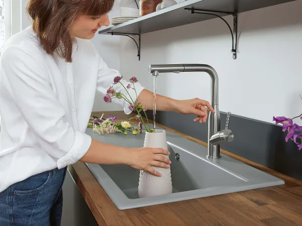 Subway Style Küchenarmatur mit Vase Über einer Subway Style Küchenspüle befüllt eine Frau eine Vase aus einer Subway Style Küchenarmatur.