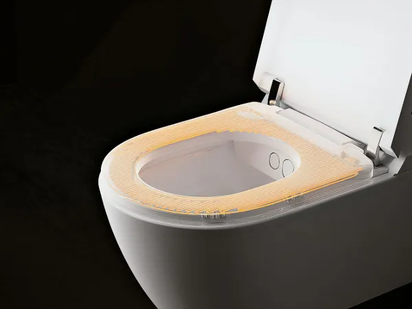 WC con doccetta ViClean di Villeroy & Boch con sedile riscaldato Una toilette high-tech con sedile riscaldato illuminato su uno sfondo scuro.