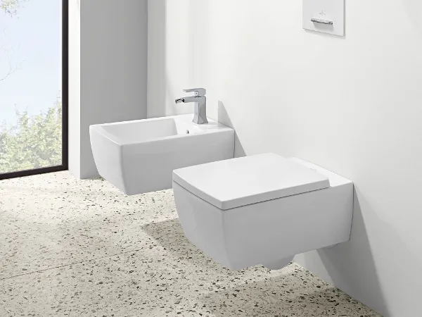 Bidé e inodoro suspendidos Memento 2.0 en blanco Mobiliario de baño moderno y minimalista con bidé e inodoro blancos frente a una gran ventana