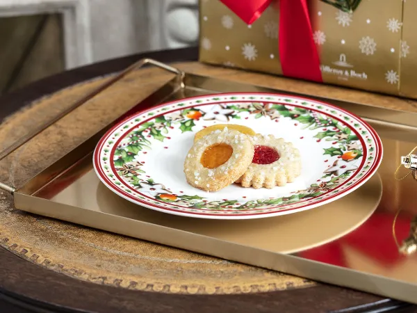 Villeroy & Boch Winter Bakery Delight plate with biscuits Christmas biscuits on a festive Winter Bakery Delight plate with a gift in the background.