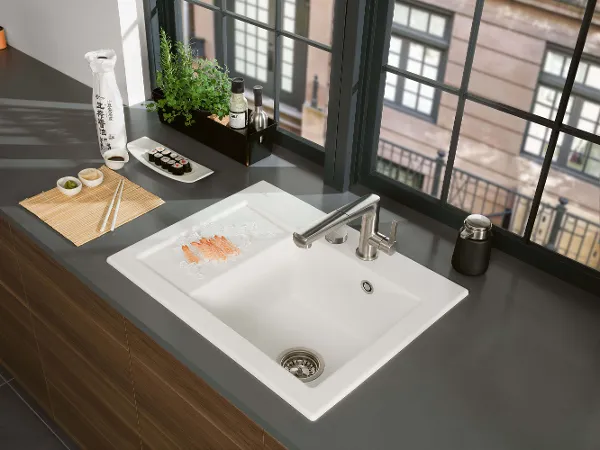 Subway 45 kitchen sink with sushi A modern kitchen sink with sushi on a plate, with a view of the city through large windows.