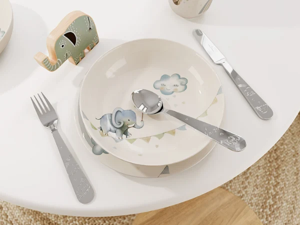 De la vaisselle pour enfants Boho Kids sur une table blanche Un ensemble de vaisselle pour enfants Boho Kids Walk like an elephant avec un motif d’éléphant sur une table blanche.