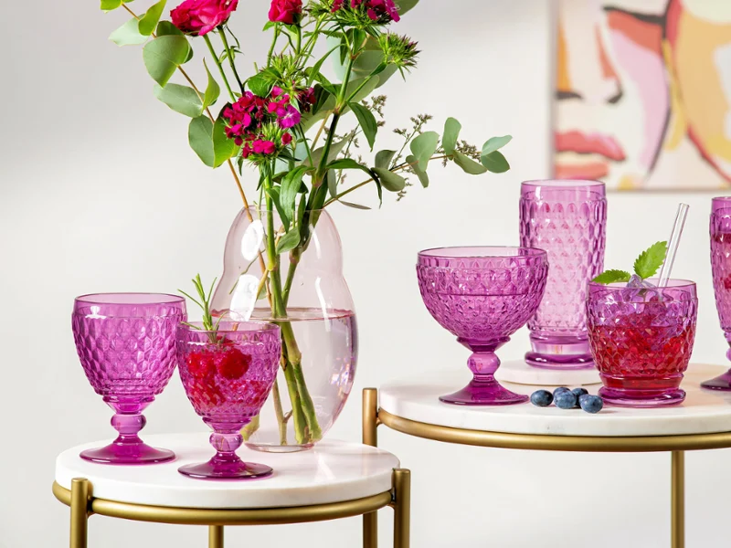 Boston Berry glassware displayed alongside a Rose Garden vase Full Boston Berry glassware collection displayed with Rose Garden vase on a coffee table.