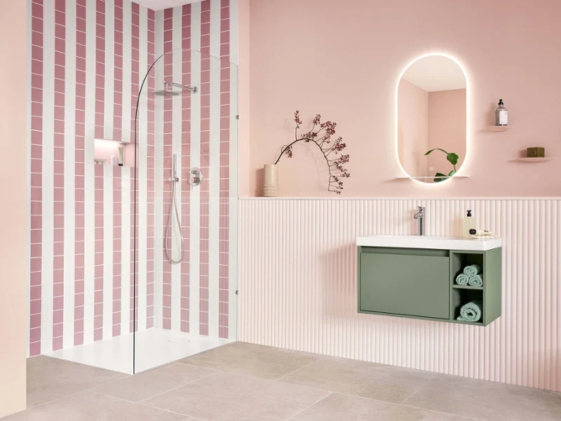 Modern bathroom with pink and white striped shower, oval mirror, wall-mounted washbasin and light-coloured wooden floor.