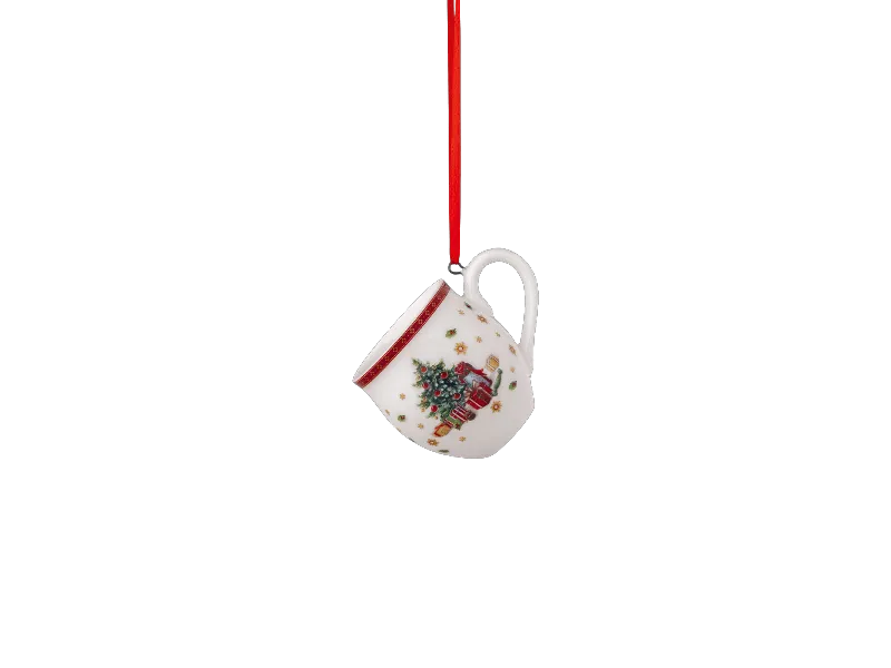 Der weiße Becher-Anhänger von Villeroy & Boch hat eine rote Schlaufe und zeigt ein Design mit Weihnachtsbaum und Geschenken.