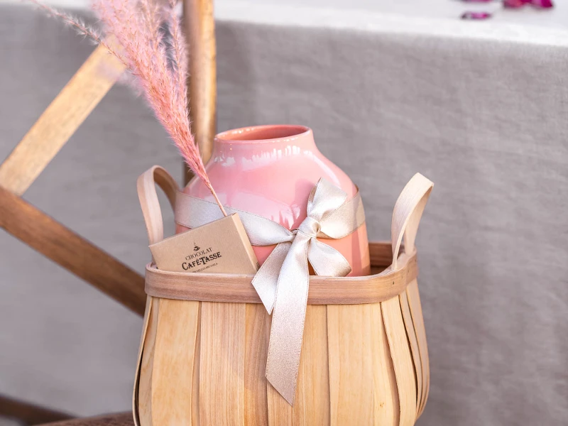 Large, pink Perlemor vase from like. by Villeroy & Boch as a gift in a wooden basket with a gray bow and pink pampas grass.