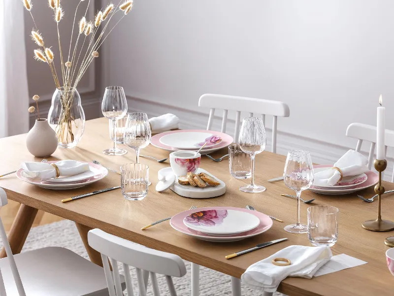 Een elegante eettafel met modern Rose Garden servies, decoratieve kaarsen en een Rose Garden vaas met pampagras.