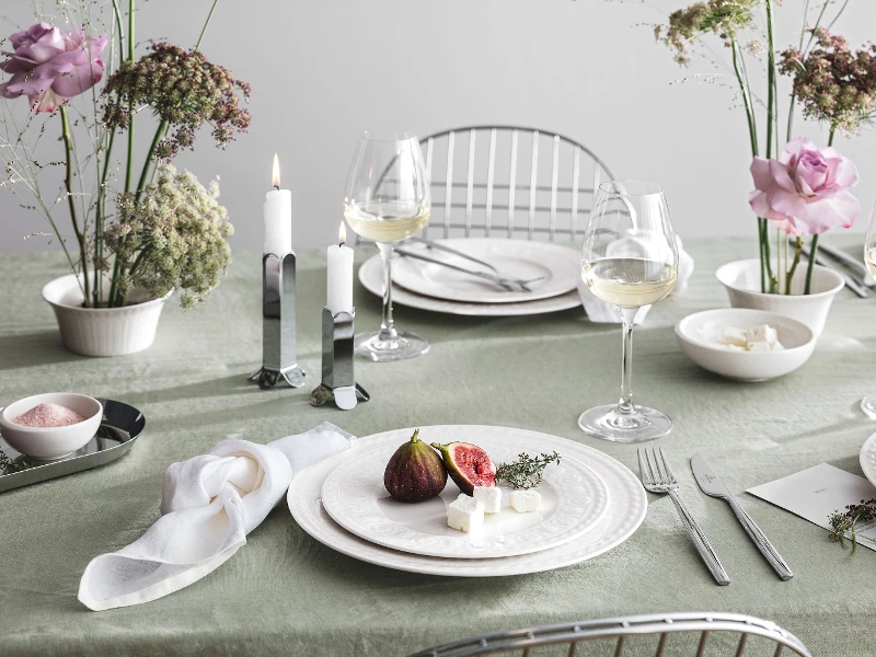 Une table dressée avec des assiettes et des couverts de table Cellini et de la vaisselle NewMoon de Villeroy & Boch.