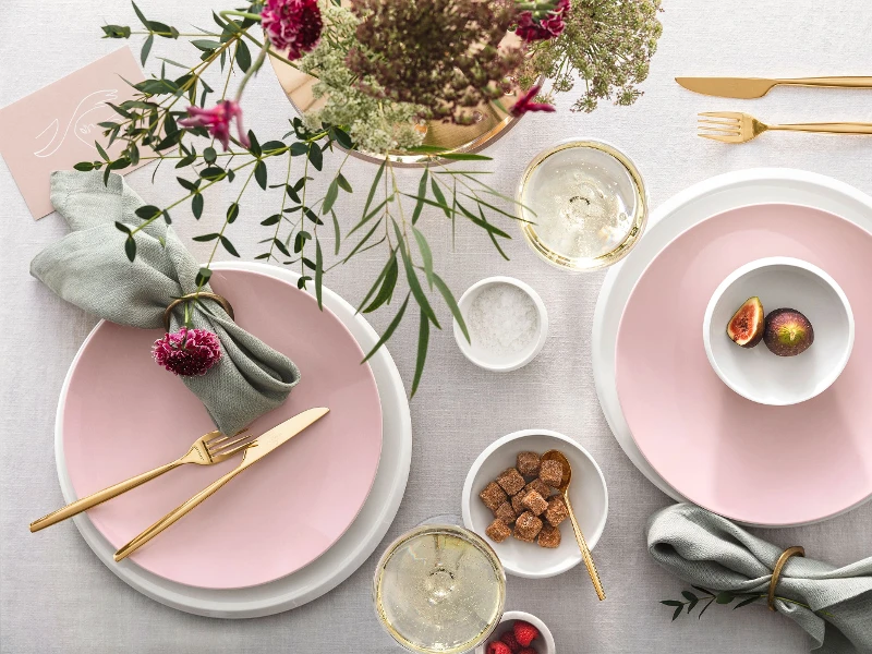 Elegant table decorations with pink Rose Garden plates, golden MetroChic flatware, fresh flowers and a touch of green, plus drinks and light snacks.