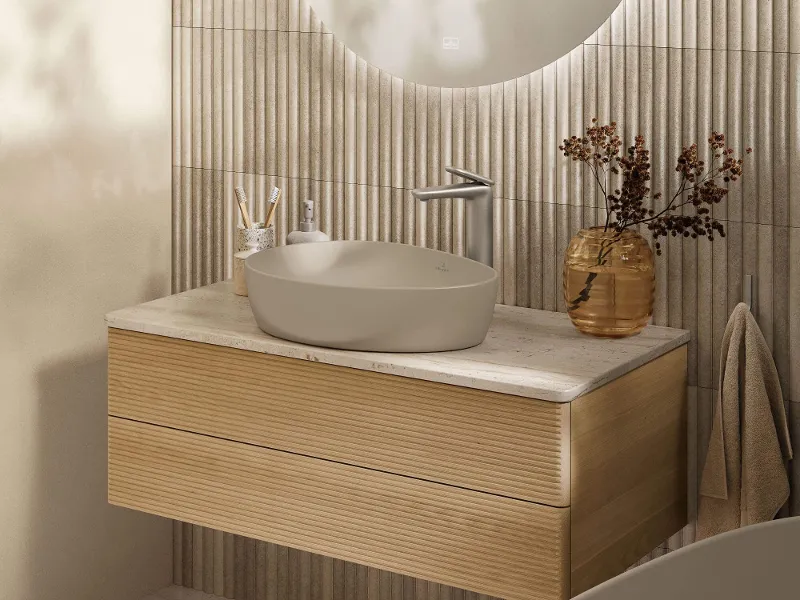 Vägghängd Subway 3.0-toalett med Universo TwistFlush från Villeroy & Boch i ett beige badrum med transparenta gardiner och ett litet fönster.