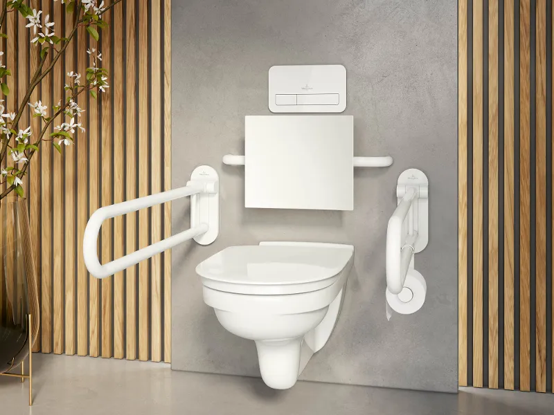 Ein modernes barrierefreies Badezimmer mit wandmontierter Toilette, Haltegriffen auf beiden Seiten, Holzlatten als Dekoration und einer grauen Wandkulisse.