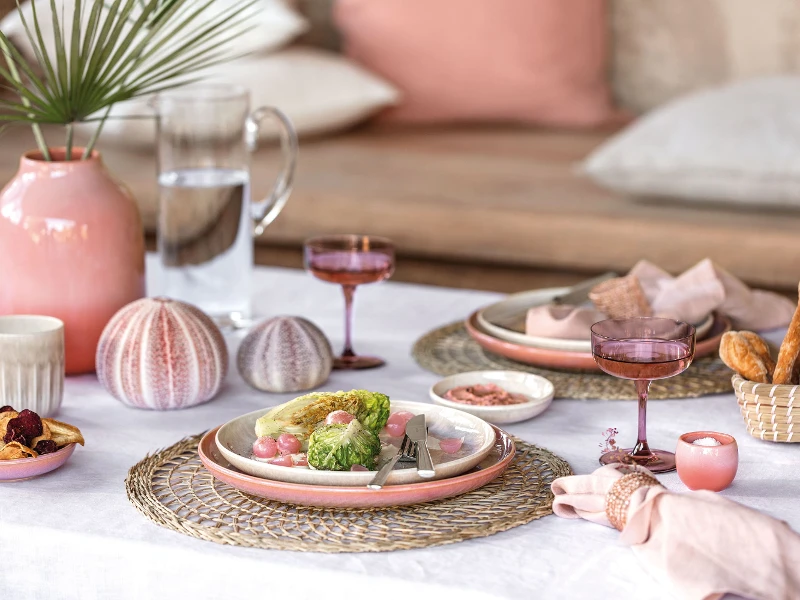 Ein gedeckter Tisch mit rosa und weißen Tellern aus der Kollektion Perlemor von like. by Villeroy & Boch.