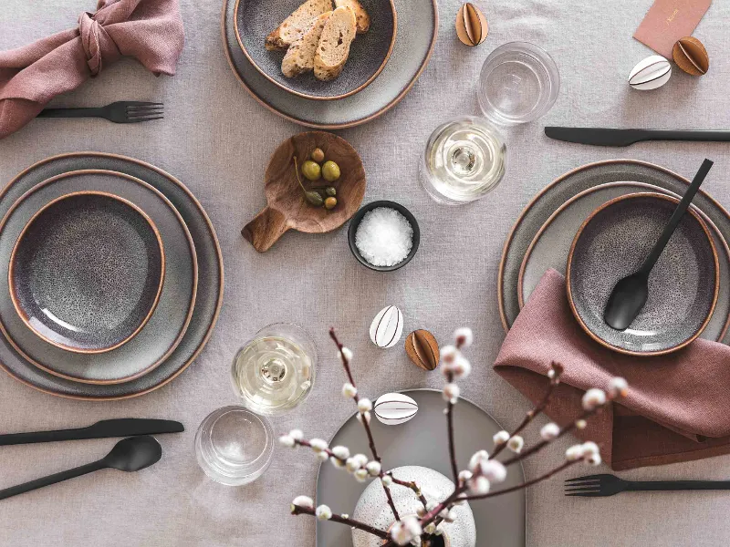 Eleganti decorazioni per la tavola con stoviglie Lave, posate Manufacture e semplici decorazioni pasquali in una paletta di colori neutri.