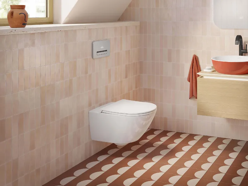 Salle de bain moderne avec des toilettes Universo TwistFlush, un plan de toilette en bois avec une vasque Artis orange et des carreaux de sol à motifs.