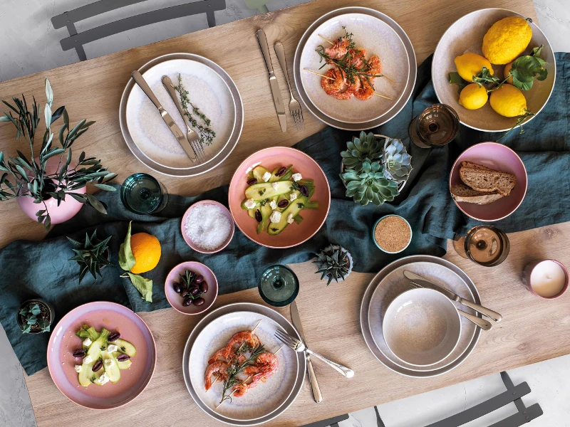 A table is set with Perlemor dinnerware and Mediterranean food.