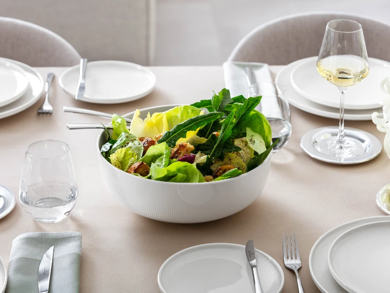 Stor Afina serveringsskål från Villeroy & Boch, fylld med sallad, på dukat bord.